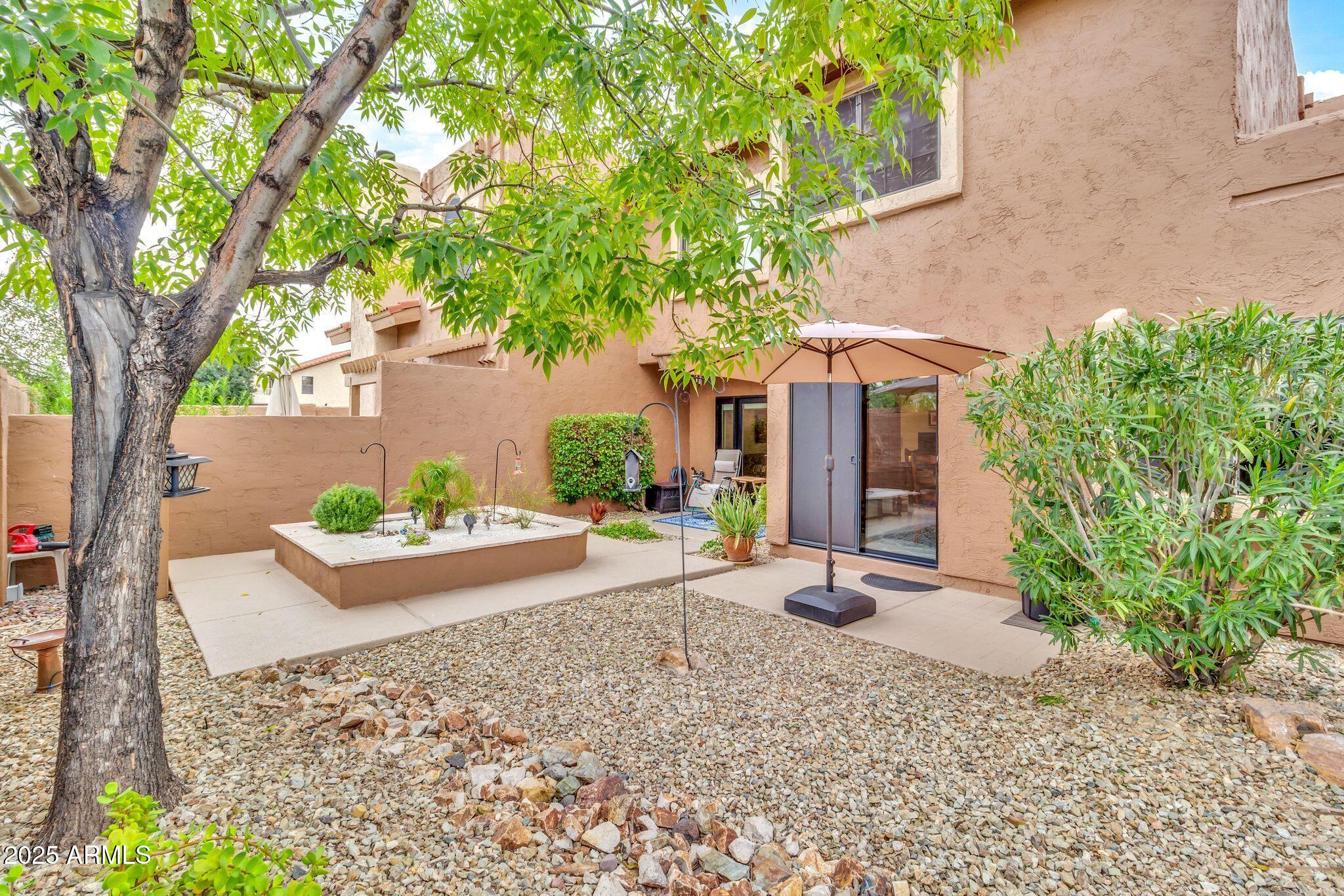 5640 East Bell Road, Unit 1055 Scottsdale, AZ 85254 - Photo 4 of 39 front view of a house with potted plants and large trees