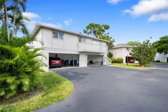 a view of a house with a garage and a car
