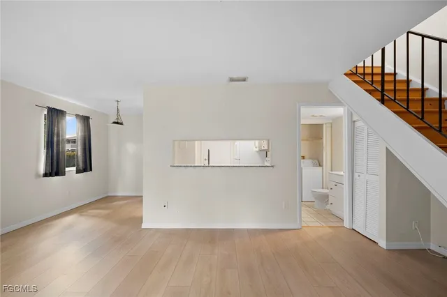 a view of a hallway with wooden floor and staircase