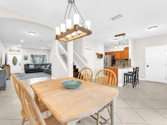 a dining room filled chandelier and kitchen view