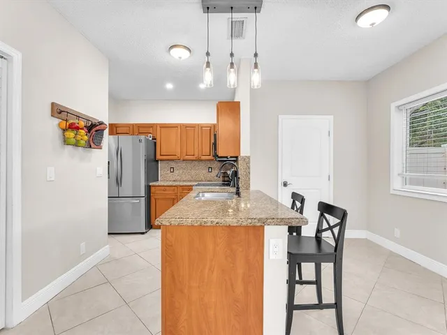 a kitchen with stainless steel appliances granite countertop a refrigerator and a sink