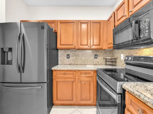 a kitchen with stainless steel appliances granite countertop a refrigerator and a stove