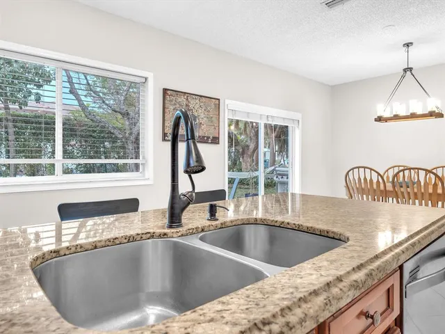 a view of a kitchen counter top a sink and cabinets