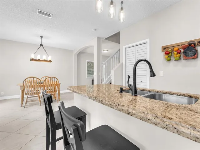 a kitchen with stainless steel appliances granite countertop a table and chairs