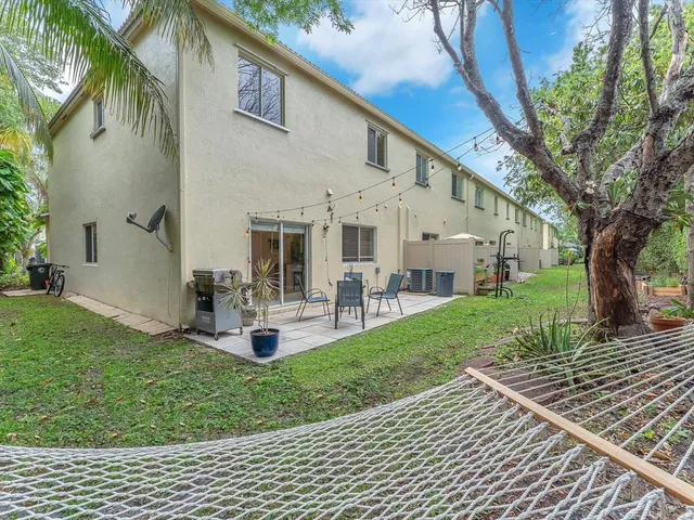 a view of a house with backyard and sitting area