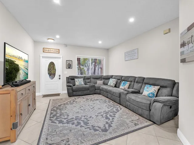 a living room with furniture flat screen tv and a couch