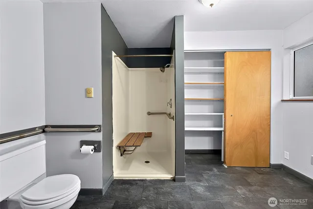 a bathroom with a toilet and a shower