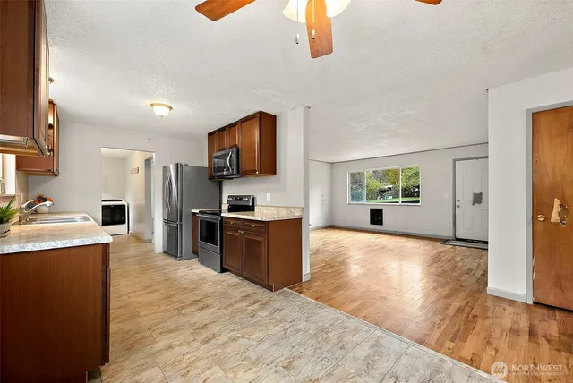a large kitchen with kitchen island a sink stainless steel appliances and cabinets