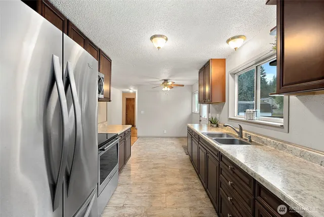 a kitchen with stainless steel appliances granite countertop a sink stove and refrigerator
