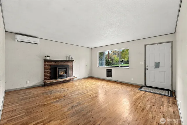 a view of empty room with wooden floor and fireplace