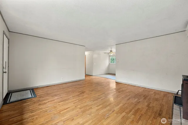an empty room with wooden floor and white walls