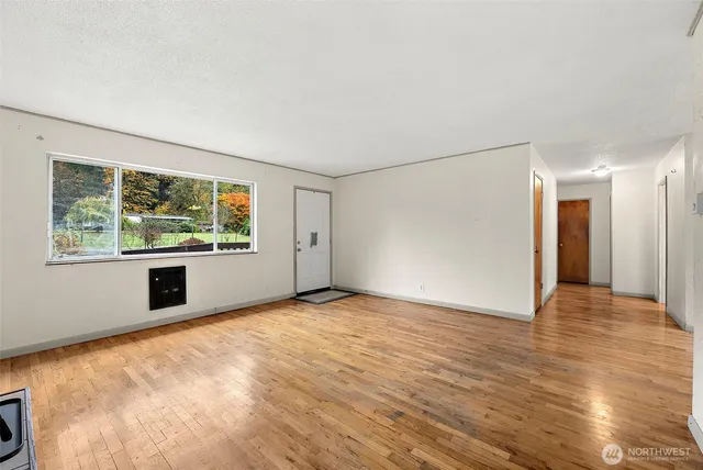 a view of a room with wooden floor and window