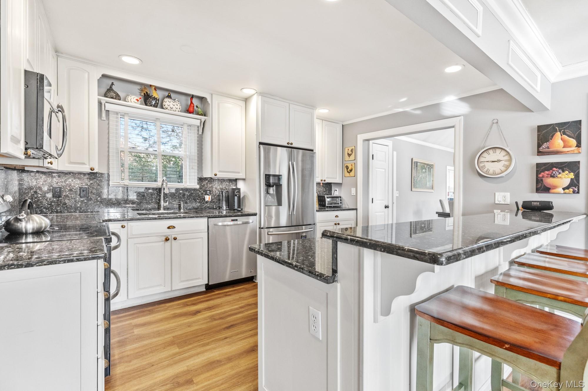 79 East Tiana Road Hampton Bays, NY 11946 - Photo 12 of 26 a kitchen with granite countertop a sink stove and refrigerator