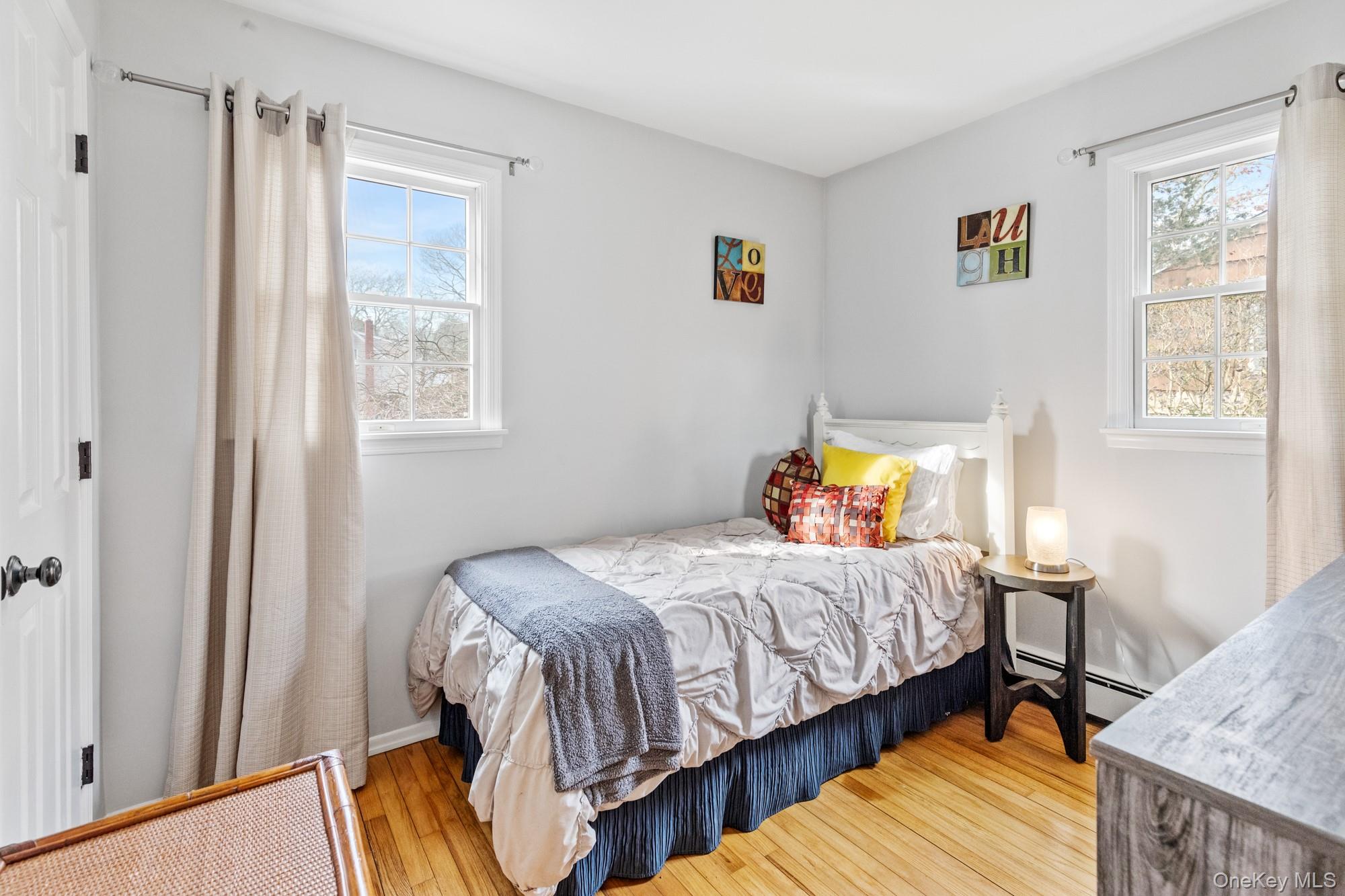 79 East Tiana Road Hampton Bays, NY 11946 - Photo 15 of 26 a bedroom with a bed and wooden floor