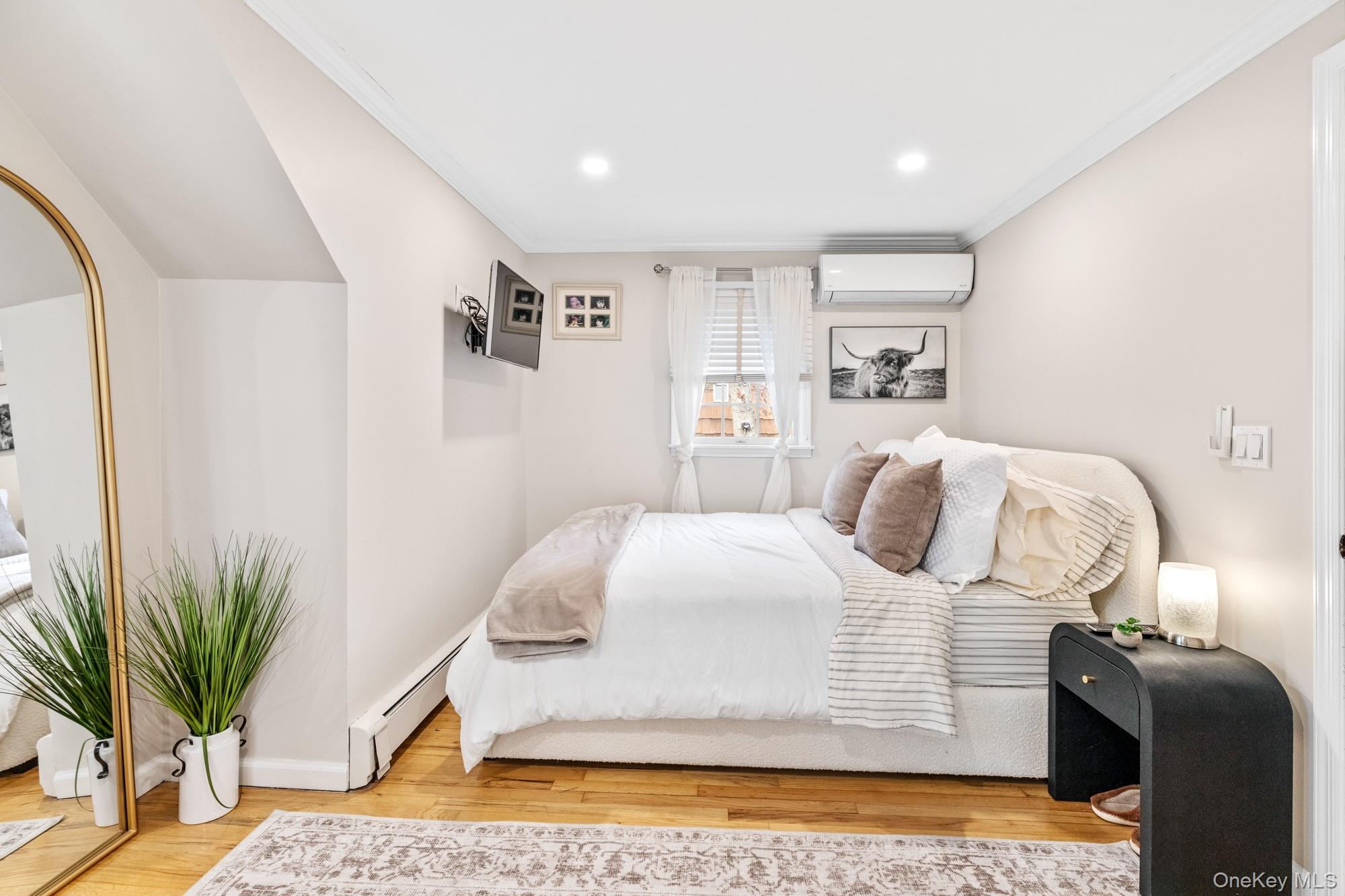 79 East Tiana Road Hampton Bays, NY 11946 - Photo 22 of 26 a bedroom with a bed and a potted plant