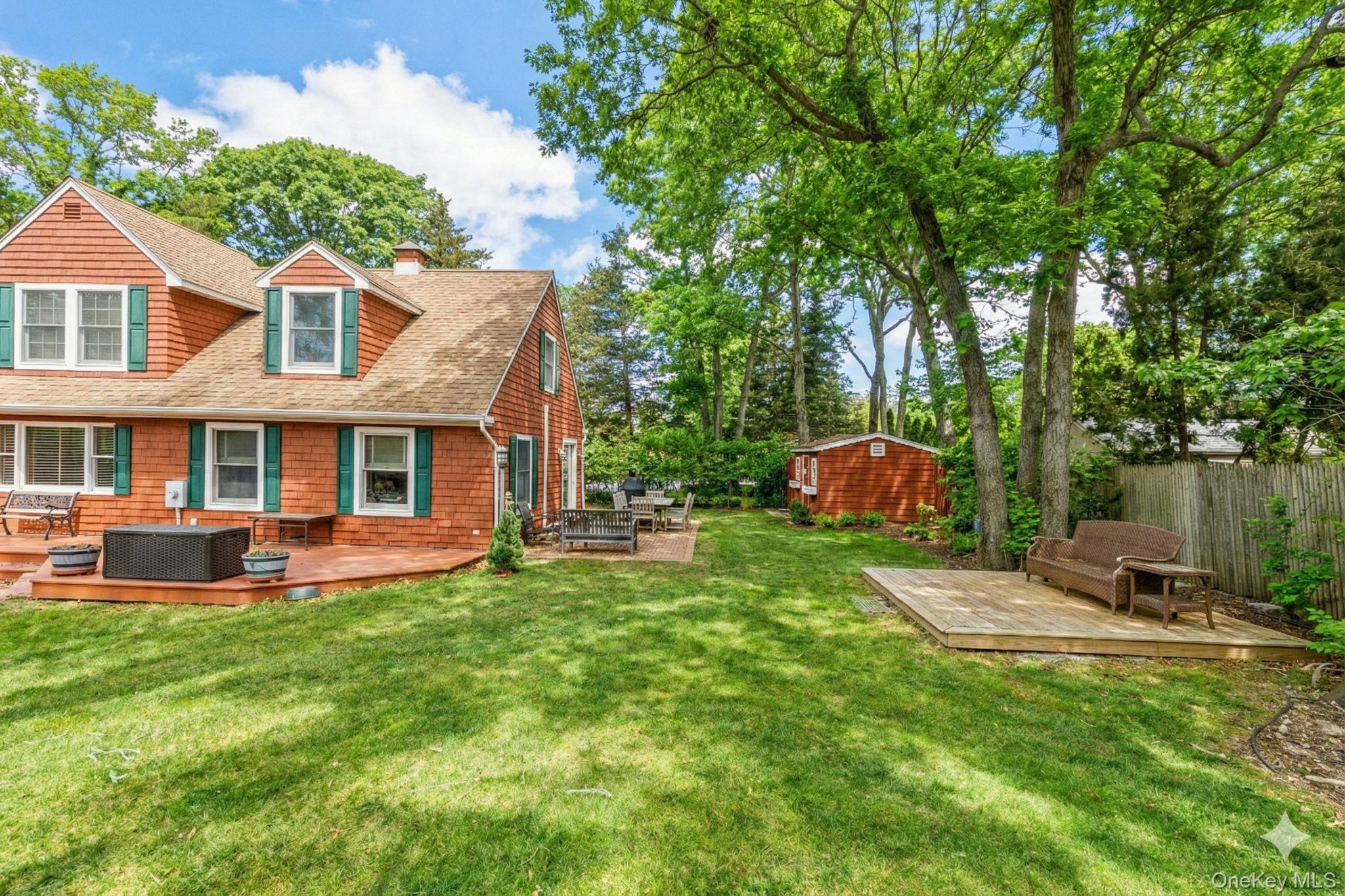 79 East Tiana Road Hampton Bays, NY 11946 - Photo 25 of 26 a front view of a house with a yard table and chairs