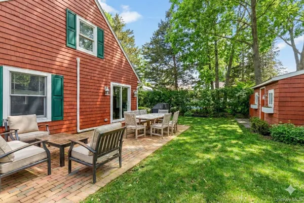a view of a house with backyard and sitting area