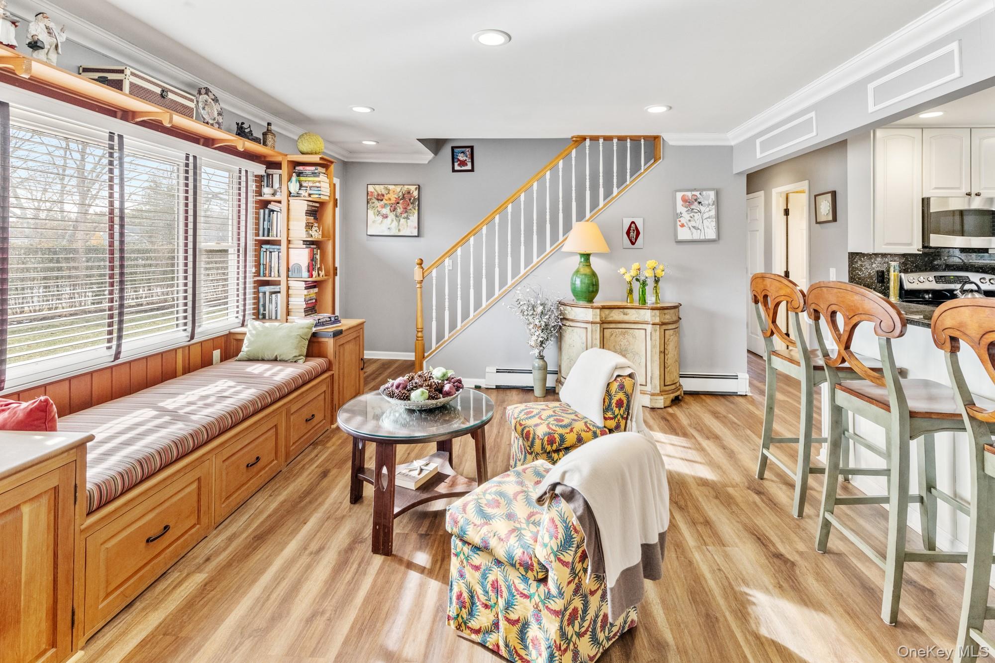 79 East Tiana Road Hampton Bays, NY 11946 - Photo 7 of 26 a living room with furniture a flat screen tv and a floor to ceiling window