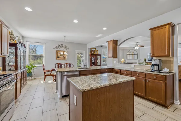 a kitchen with stainless steel appliances granite countertop a refrigerator and a stove