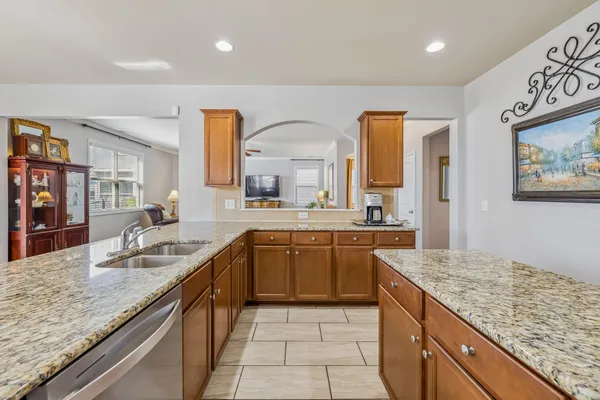 a kitchen with stainless steel appliances granite countertop wooden cabinets a sink and dishwasher