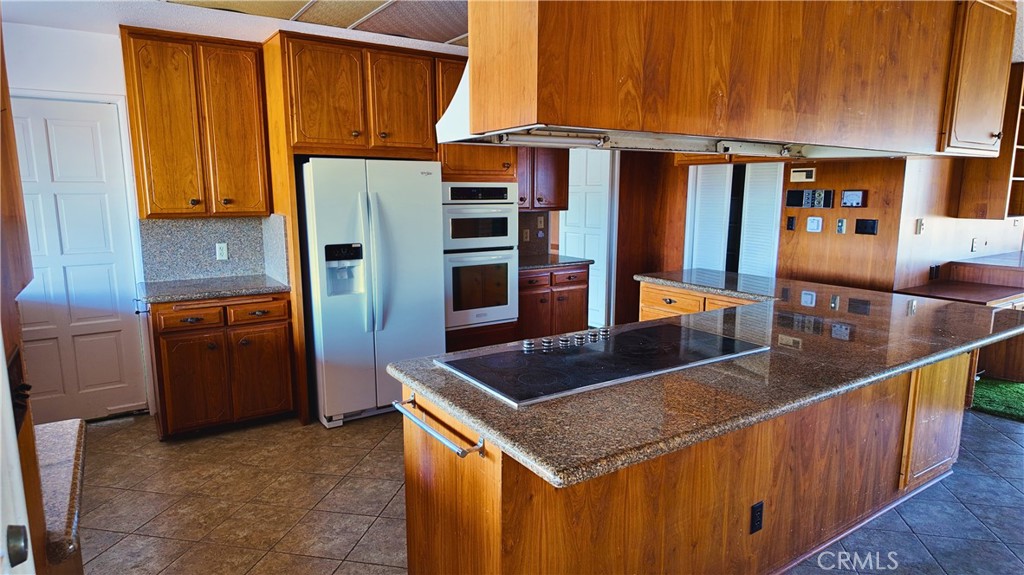 17250 Waugh Ranch Road Riverside, CA 92503 - Photo 11 of 16 a kitchen with stainless steel appliances granite countertop a counter top and a refrigerator