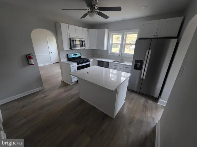 a large kitchen with a sink a refrigerator and a stove top oven