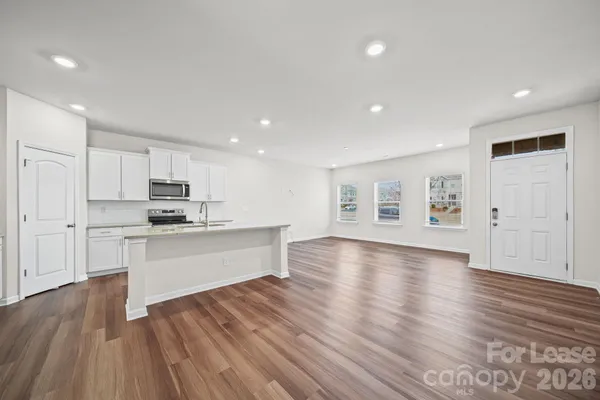 a large kitchen with cabinets wooden floor and stainless steel appliances