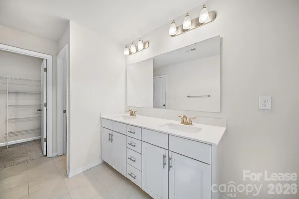 a bathroom with a double vanity sink mirror and chandelier