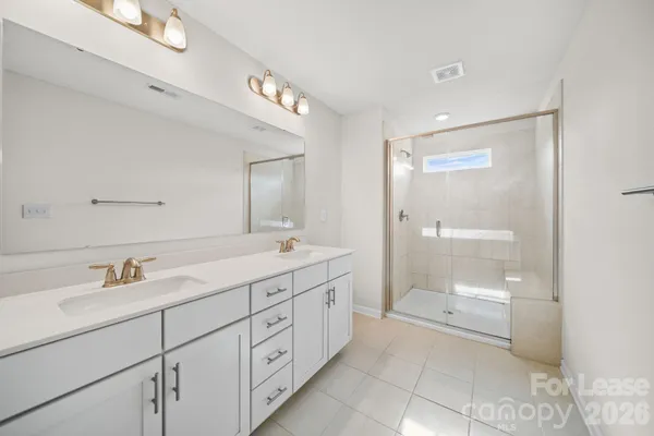 a spacious bathroom with a shower a sink and a large mirror