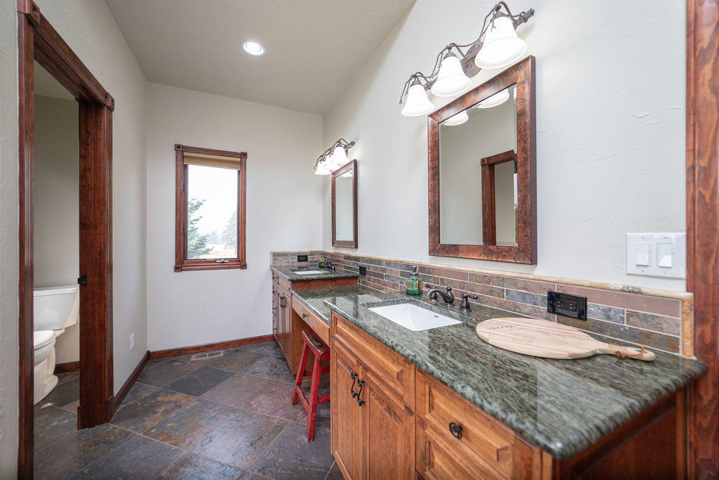 60675 Billadeau Road Bend, OR 97702 - Photo 22 of 87 a bathroom with a granite countertop sink and a mirror