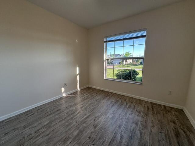 519 Southwest Laconic Avenue Port St. Lucie, FL 34953 - Photo 4 of 10 a view of an empty room with wooden floor and a window
