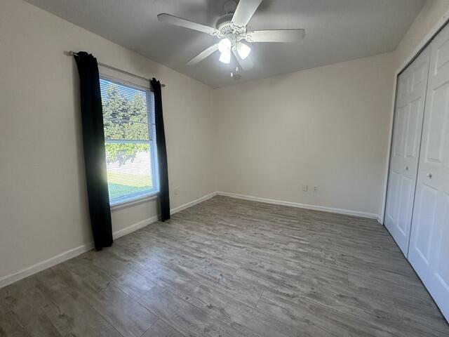 519 Southwest Laconic Avenue Port St. Lucie, FL 34953 - Photo 7 of 10 an empty room with wooden floor and windows