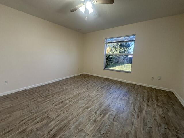 519 Southwest Laconic Avenue Port St. Lucie, FL 34953 - Photo 8 of 10 wooden floor in an empty room with a window