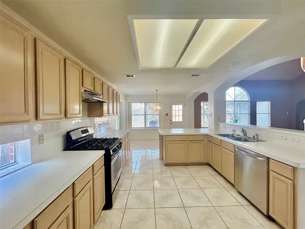 a large kitchen with stainless steel appliances granite countertop a sink and cabinets