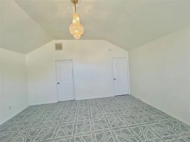 an empty room with windows and ceiling fan