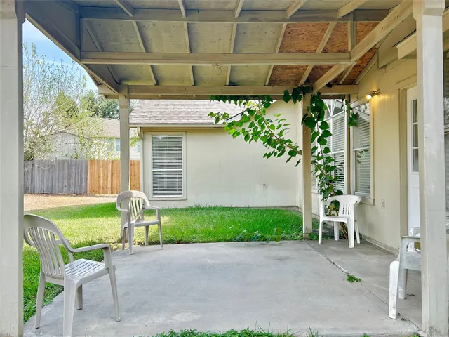 a view of a chair and table in backyard of the house