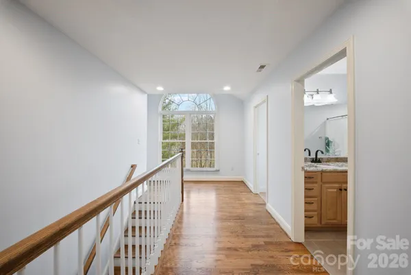 a view of a hallway with wooden floor and windows