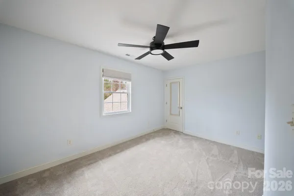 a view of room with ceiling fan and window