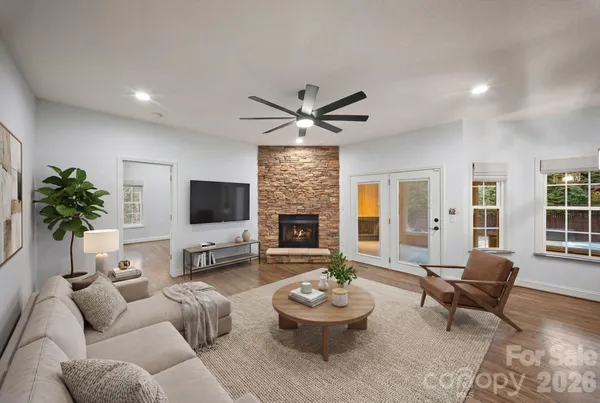 a living room with furniture a fireplace and a large window