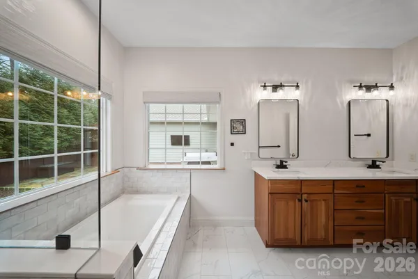 a bathroom with a tub sink and mirror
