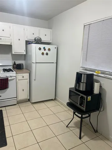 a kitchen with cabinets a refrigerator and a stove top oven