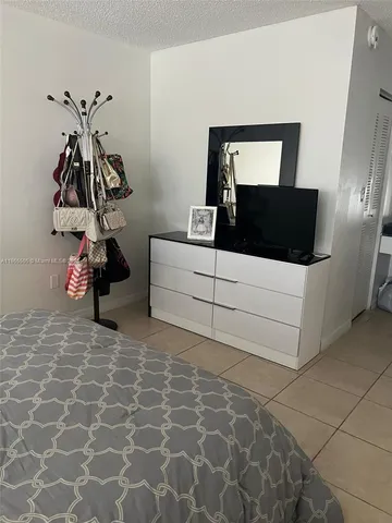 a living room with a couch and a potted plant on the wall