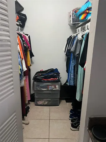a view of walk in closet with clothes and shoes