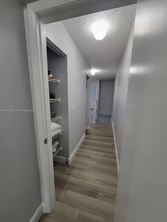 a view of a hallway with wooden floor and entryway