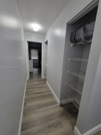 a view of a hallway with wooden floor and stairs