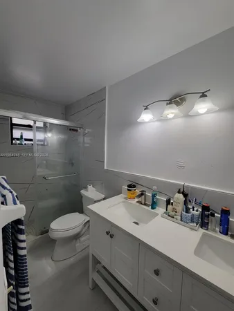 a bathroom with a sink mirror vanity and toilet