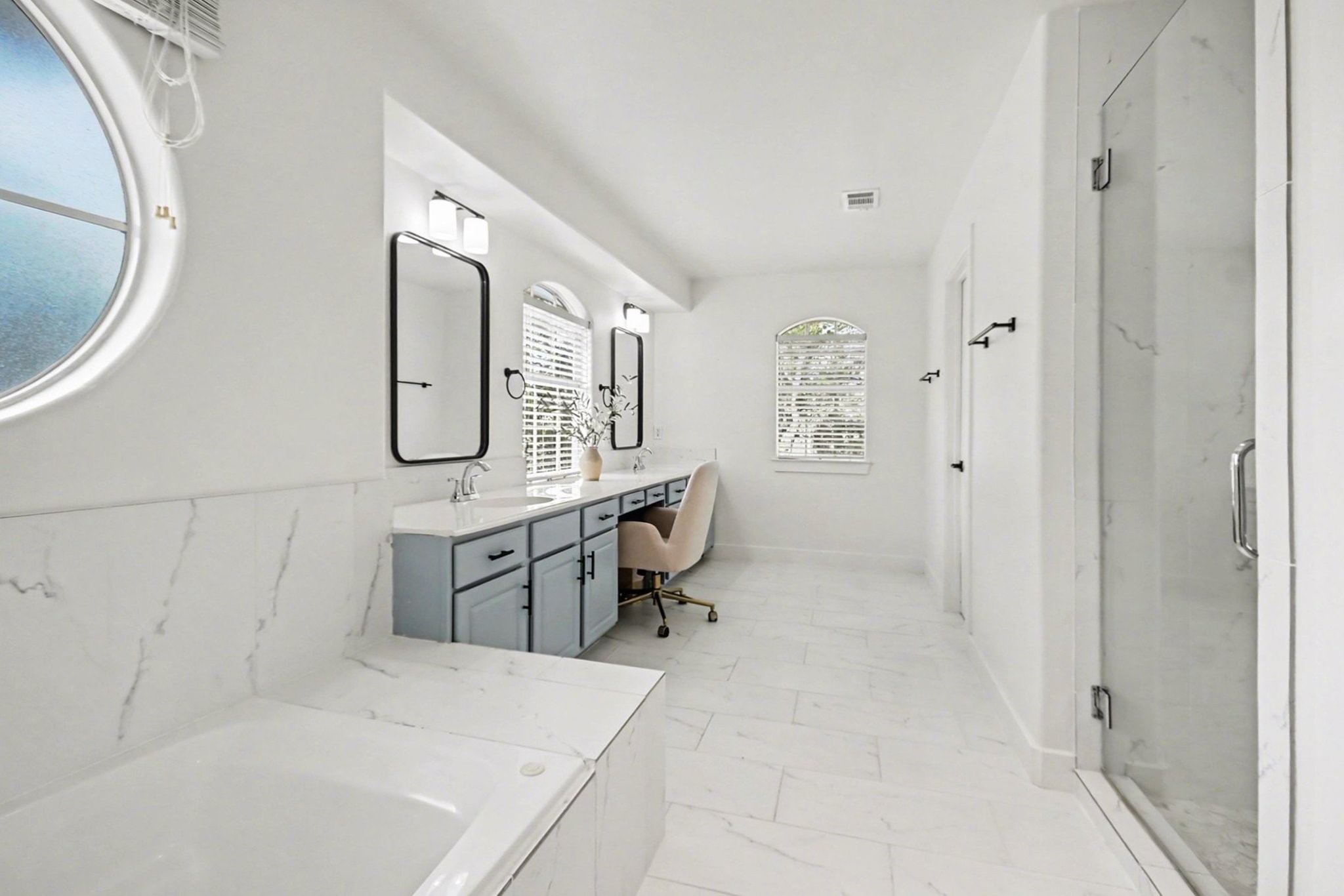 1470 Springrock Lane, Unit 6 Houston, TX 77055 - Photo 17 of 32 This is a spacious, bright bathroom featuring a large walk-in shower, a bathtub, dual sinks with stylish mirrors, and a vanity area. It has modern fixtures and a sleek, minimalist design.