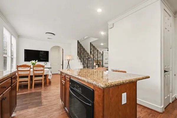 a kitchen with granite countertop a refrigerator and wooden floor