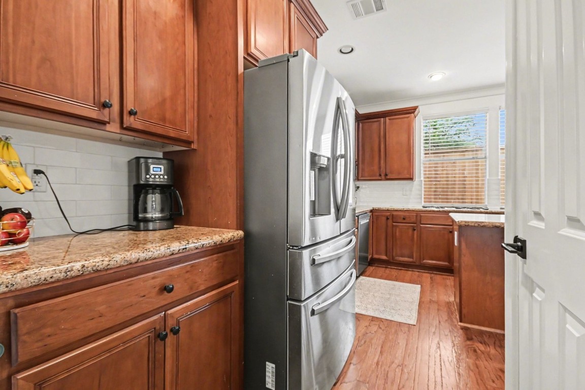 1470 Springrock Lane, Unit 6 Houston, TX 77055 - Photo 9 of 32 a kitchen with granite countertop a refrigerator and wooden floor