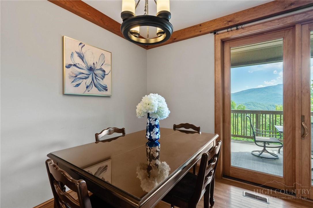 142 Evening View Lane, Unit CA3 Boone, NC 28607 - Photo 12 of 41 a view of a dining room with furniture wooden floor and chandelier